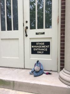 Eeyore sitting in front of the Stage Management Entrance