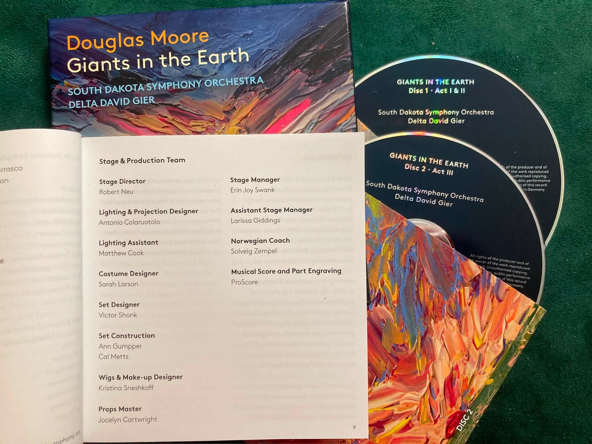 The CD cover, liner notes, and 2 CDs are shown for the recording of Giants in the Earth by the South Dakota Symphony Orchestra. The liner notes are open to the page of technical credits including Erin Joy Swank as stage manager.